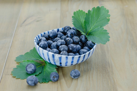 碗里的蓝莓木制背景上碗里的蓝莓图片