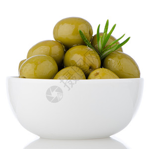 白色陶瓷碗里的绿橄榄白背景的绿橄榄图片