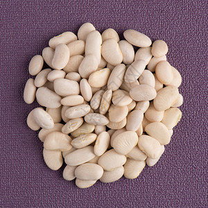 紫色圈白色豆子的顶端视野紫色黑乙烯基底的白豆圈背景