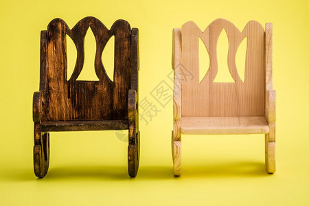 黄色背景的手工制小型木椅子图片