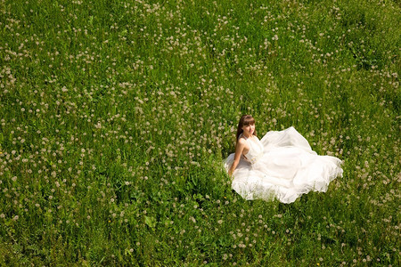 穿着白色衣服的女孩坐在草地上图片