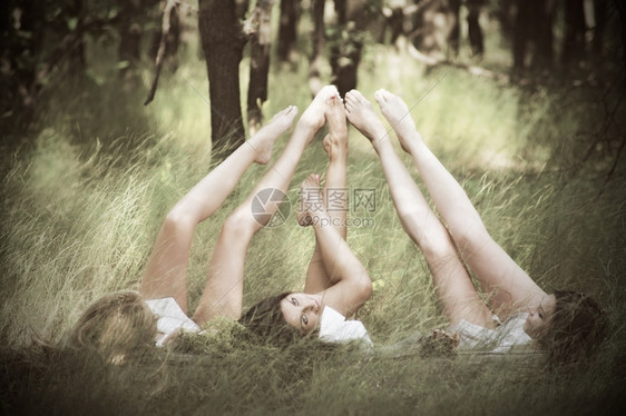 三个女孩躺在草地上图片