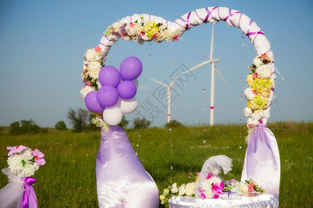 气球拱门与风车一起在田里举行婚礼仪式背景
