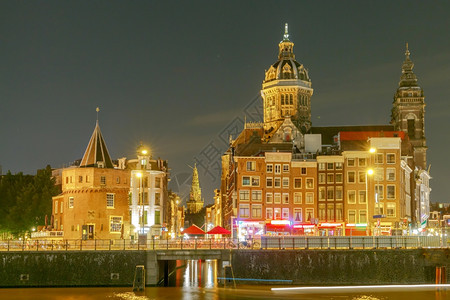 荷兰圣尼古拉斯的阿姆特丹运河和巴西利卡夜市景图片