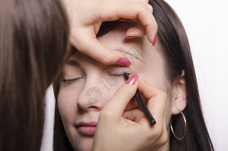 化妆师在模特的脸上做化妆品她画了眼睫毛模特图片