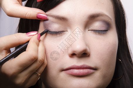 化妆师在模型Q39上做化妆品脸她画上层眼皮模型的阴影图片
