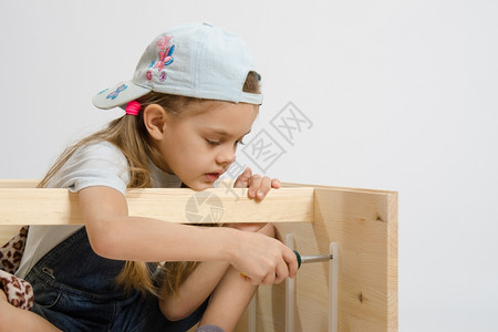 6岁女孩玩耍和收集木制柜子图片