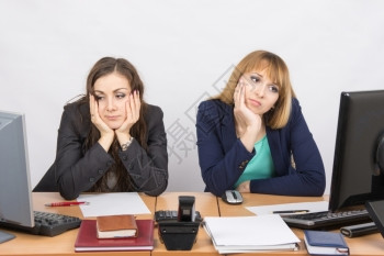两名年轻的办公室工人厌倦了坐在电脑前着图片