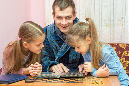 爸爸陪着女儿们玩硬币图片