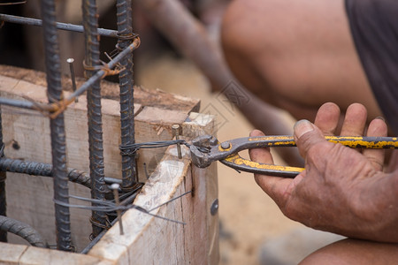 在建筑工地修炼钢管时与铁钉一起工作的建筑人近身手图片