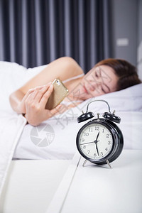 女人在卧室的床上用智能手机图片