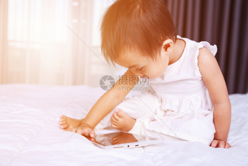 婴儿想在家里床上玩看平板电脑图片