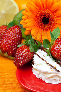 柠檬格贝拉蛋糕和草莓落在橙色织物上图片