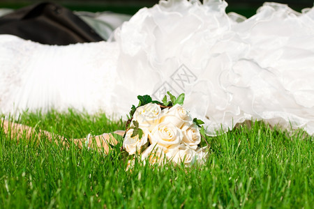 新娘对着躺在绿草上的衣服图片
