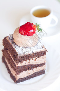美丽的蛋糕有草莓和茶叶白色背景的图片