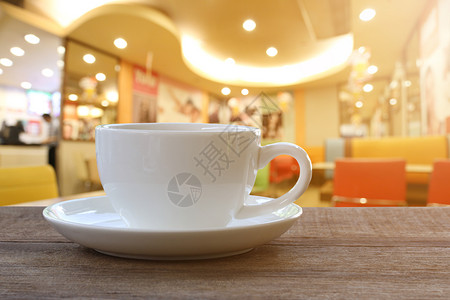 咖啡店木桌上的白咖啡杯背景模糊咖啡店木桌上的白咖啡杯背景模糊信条风格效果图片背景