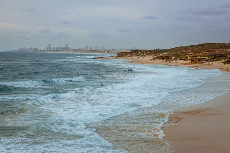 日落时在以色列帕尔马希姆海滩的波浪上冲图片