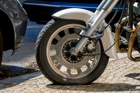 摩托车锁安全号码挂锁挡住街上的摩托车轮背景