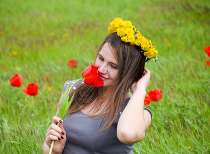 一位头戴花圈的女孩一位在郁金香花丛中的美丽仙女年轻孩一位身着红花和绿地背景的女孩肖像一位在郁金香花丛中的美丽仙女图片