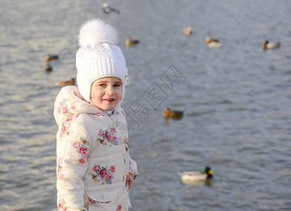 小女孩在湖中与鸭子一起的湖中图片