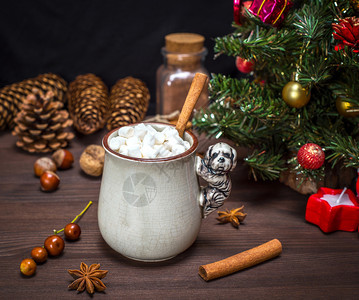 棕色木制桌子上一个陶瓷杯中白棉花糖片的热巧克力和白色棉花糖片图片