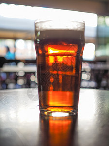 鲜啤啤酒吧喝一品脱啤专注于和模糊的背景布基背景