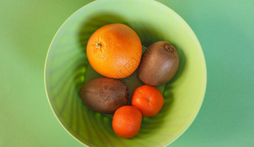 塑料碗中的水果塑料碗中的很多水果包括橙子kiwi和橘子图片