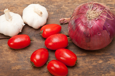 大蒜和西红柿意利食品在生锈桌上的基图片
