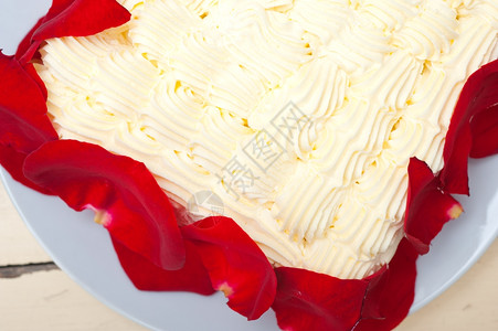 玫瑰花瓣蛋糕带红玫瑰花瓣的奶油芒果蛋糕背景
