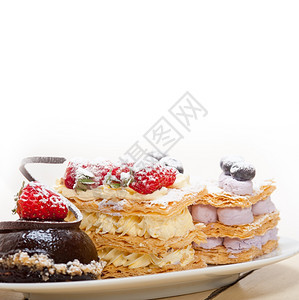 选择新鲜奶油拿破仑和巧克力慕斯蛋糕甜板图片