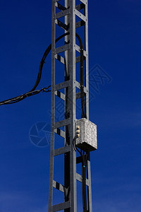 高压塔后面有蓝色天空的高压塔图片
