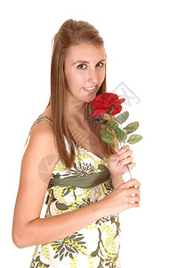 一位年轻美女穿着红玫瑰礼服站在工作室微笑着白背景图片