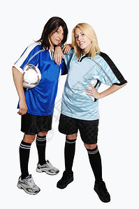 两个年轻漂亮的女足球员拿着穿俱乐部的制服站在工作室里寻找浅灰色背景图片