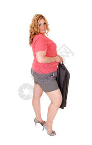 身穿灰短裤的年轻金发美女穿着高跟鞋的外套站在白背景的隔离地带图片