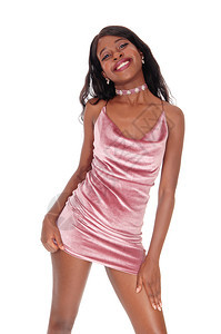 一位美丽的非洲年轻女子穿着短的粉红裙子微笑着与白种背景隔绝图片