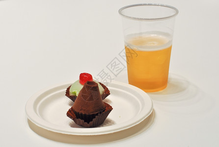 白桌上的蛋糕和啤酒巧克力水果蛋糕白桌上的啤酒图片