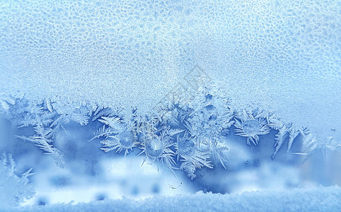 窗玻璃上美丽的冰面图案和冷冻水滴图片