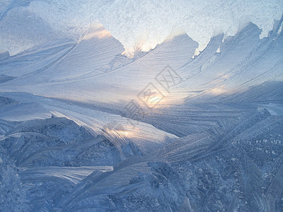 美丽的冰面图案和冬季玻璃上的阳光背景图片