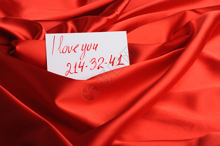 红绸上的纸条一句我爱你和一个虚构的电话号码唇膏画高清图片