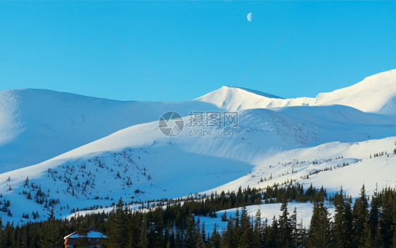 早安的山地全景天空中长蓝色的日出阴影和月亮德拉霍布特滑雪度假胜地亚森贾别墅扎卡尔帕特什地区喀尔巴阡山乌克兰图片