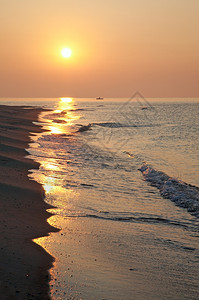 阳光照的沙岸和渔船远处的光影图片