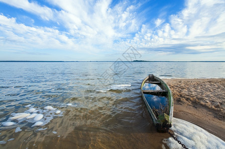 湖岸附近淹水的老木制渔船和后面的夏日天空乌克兰斯维提亚兹图片