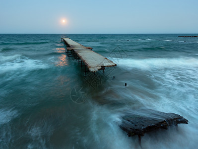 夜海浪景被毁坏的码头和天空中月亮黑海保加利亚图片