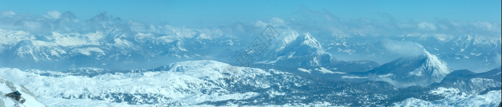 Dachstein山顶和岩石坡上的房屋奥地利的冬季风景图片