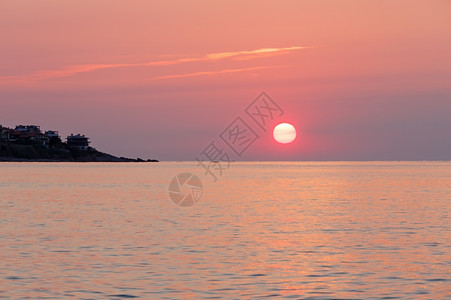 粉色云彩日出海景粉色天空的太阳和水面反射背景