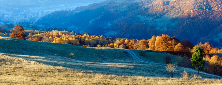 秋季迷雾山坡和谷村庄的农公路全景图片