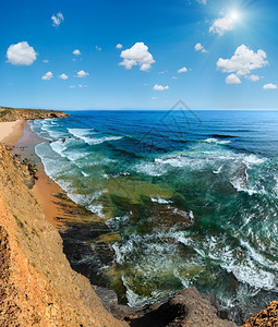 夏季大西洋海岸景观和Monte Clerigo海滩(葡萄牙阿尔杰苏、加夫),深蓝天空有积云和阳光。 三缝合高分辨率图像。图片