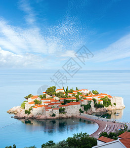 SvetiStefan海口的清晨景色与海滩和城镇旅馆MontenegroBudva附近和上面的蓝光天空背景图片