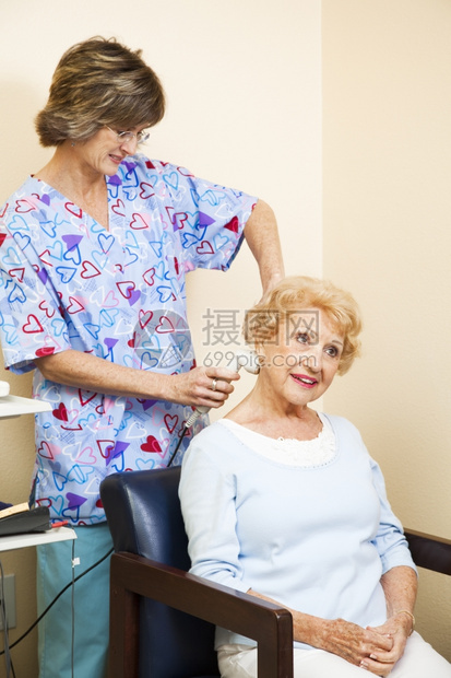 老年妇女因颈部疼痛而接受超声波治疗由按摩师护士负责图片