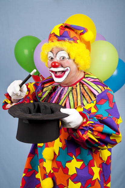笑的生日小丑用顶帽子和魔杖耍术图片